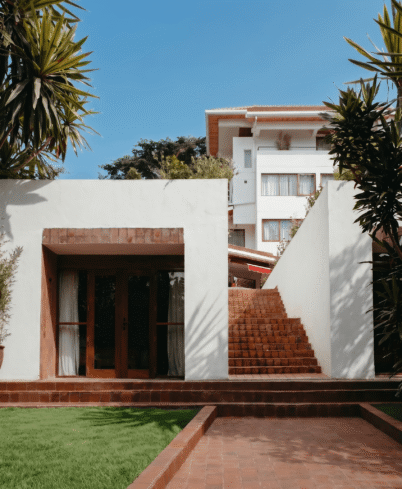 Luxurious hotel exterior with lush greenery, modern architecture, and inviting entrance, perfect for a serene getaway.